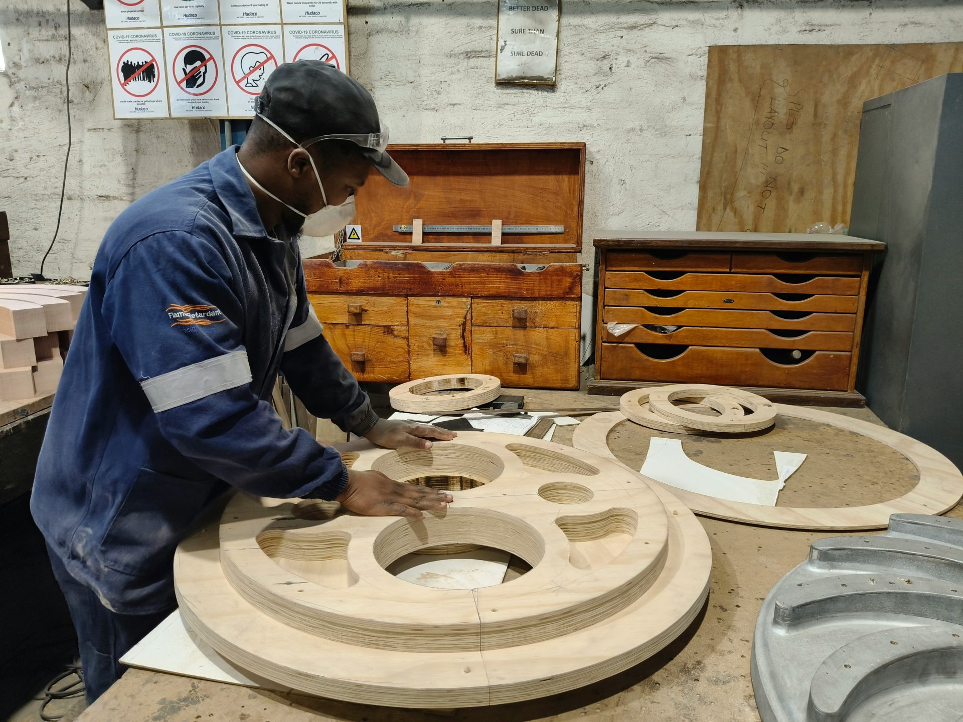 A worker examines wooden molds in a workshop.