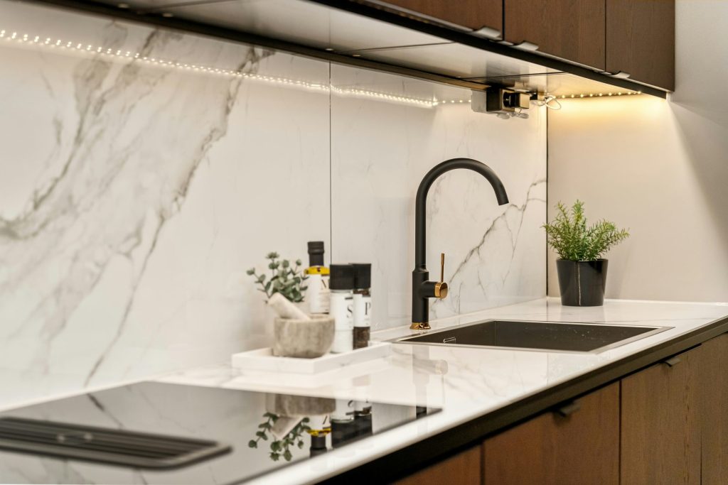 A kitchen with marble counter tops and wooden cabinets
