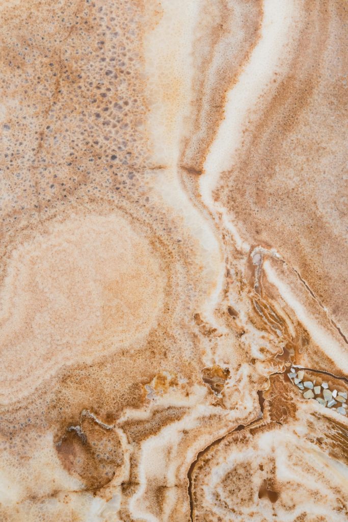 Detailed close-up of a natural stone texture with earthy hues and intricate patterns.